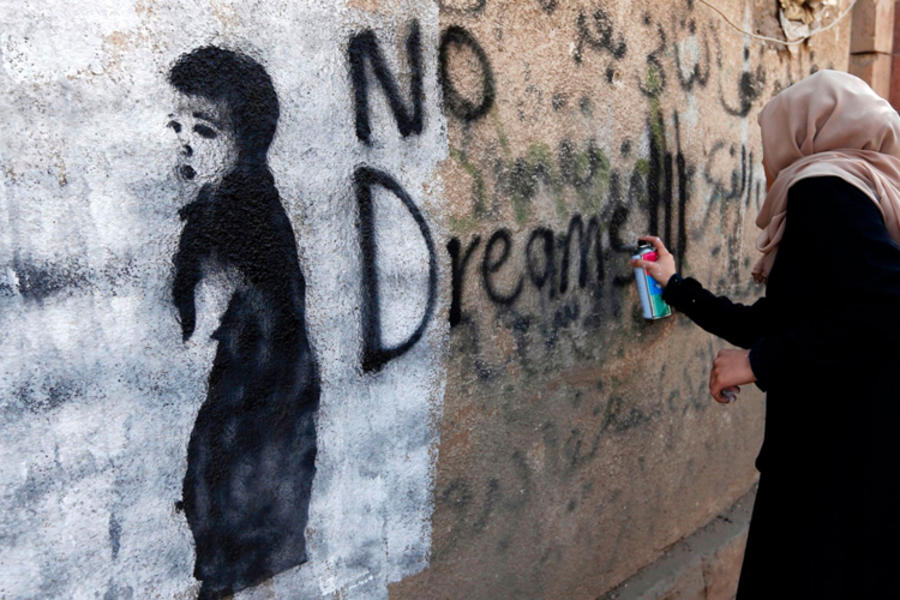 Una mujer deja un graffiti en la pared sur de la Universidad de Sanaa, en la capital yemenó (Foto: Mohammed Huwais / AFP / Getty Images).