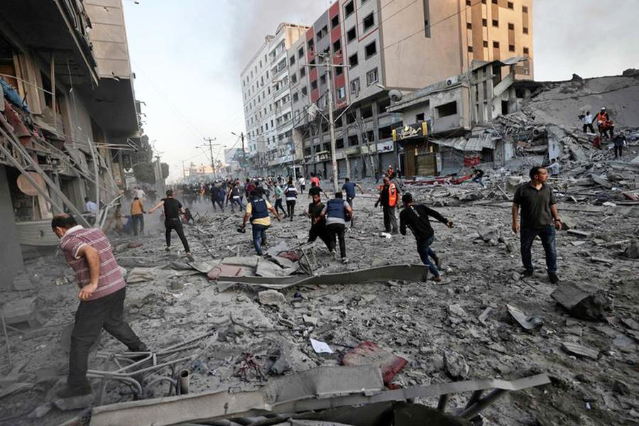 Ciudadanos rescatistas se reúnen en medio de los escombros frente a la torre de Al-Sharouk, derrumbada después de ser alcanzada por un ataque aéreo israelí, en la ciudad de Gaza. Foto: AFP.