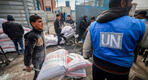 Palestinos desplazados reciben ayuda alimentaria en centros de Naciones Unidas en Rafah. Foto: AFP.