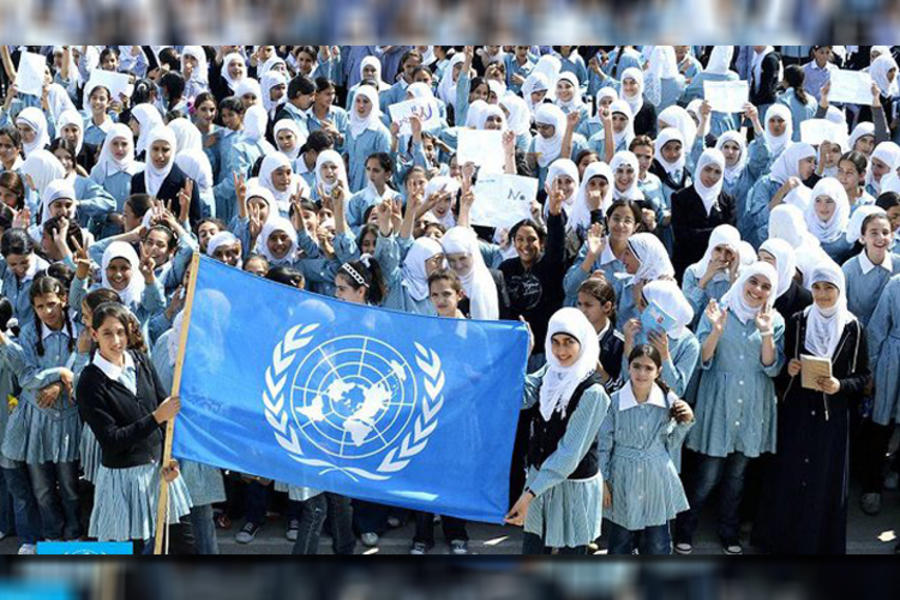 Niños en Gaza posan con la bandera de UNRWA (Foto: Days of Palestine).