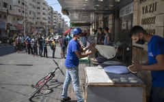 Palestinos hacen fila frente a una panadería para comprar pan durante el bloque impuesto tras el descubrimiento de nuevos casos de coronavirus en la Franja de Gaza. (AFP)