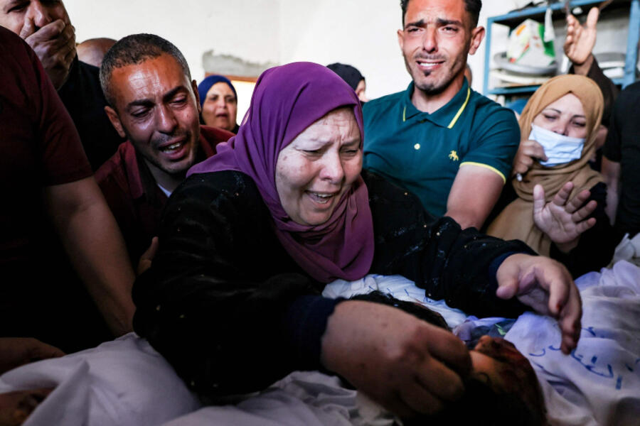 La abuela y los familiares de tres niños de la familia Al-Tanani, asesinados en un ataque aéreo israelí, lloran sobre sus cuerpos antes de su entierro en Beit Lahya, en el norte de la Franja de Gaza, Palestina, 14 de mayo de 2021. Foto: AFP.
