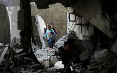 Niños palestinos caminan entre escombros tras un ataque del régimen israelí a edificios residenciales en Rafah, Franja de Gaza | Diciembre 14, 2023 (Foto: AP)