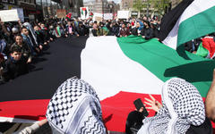 Manifestantes flamean bandera palestina en protesta. Foto: AFP.