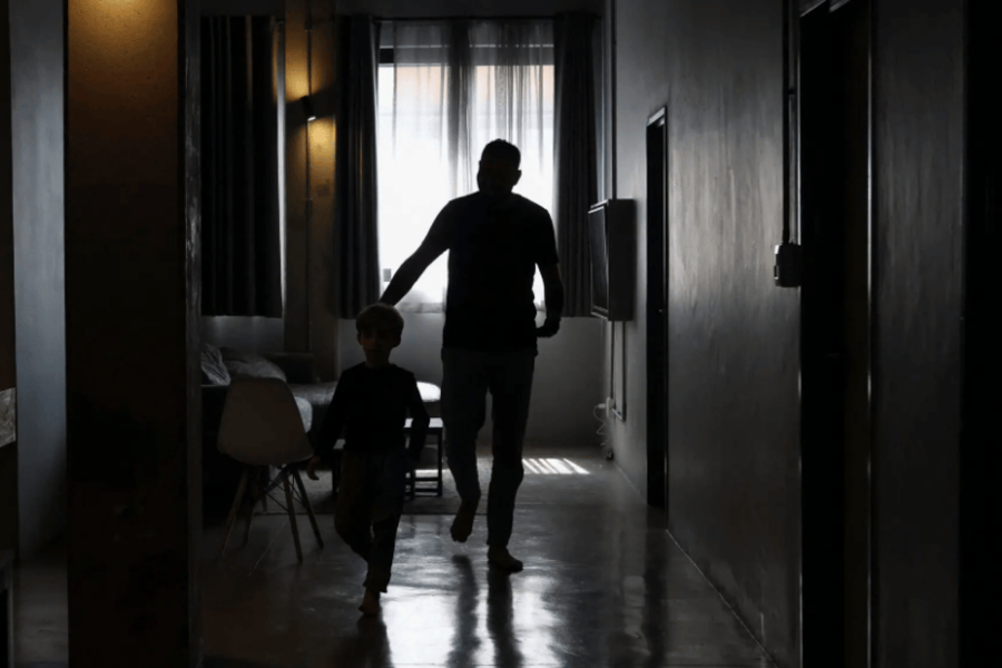 Un hombre palestino, que llegó a Sudáfrica junto a otros, con su hijo en un lugar no revelado de Johannesburgo, el viernes. Foto: Reuters.