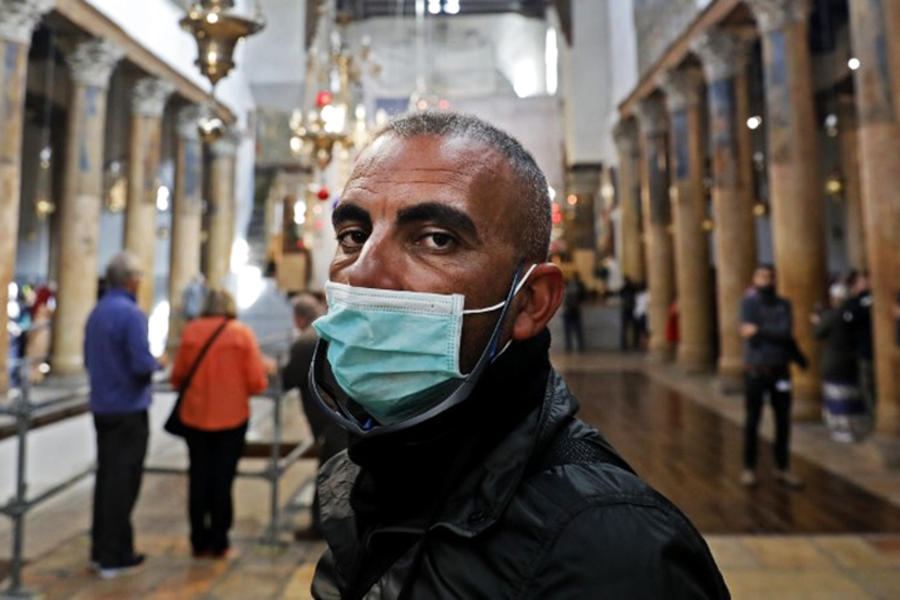 Personas con máscaras visitan la Iglesia de la Natividad, en la ciudad cisjordana de Belén, el 5 de marzo de 2020