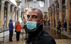 Personas con máscaras visitan la Iglesia de la Natividad, en la ciudad cisjordana de Belén, el 5 de marzo de 2020