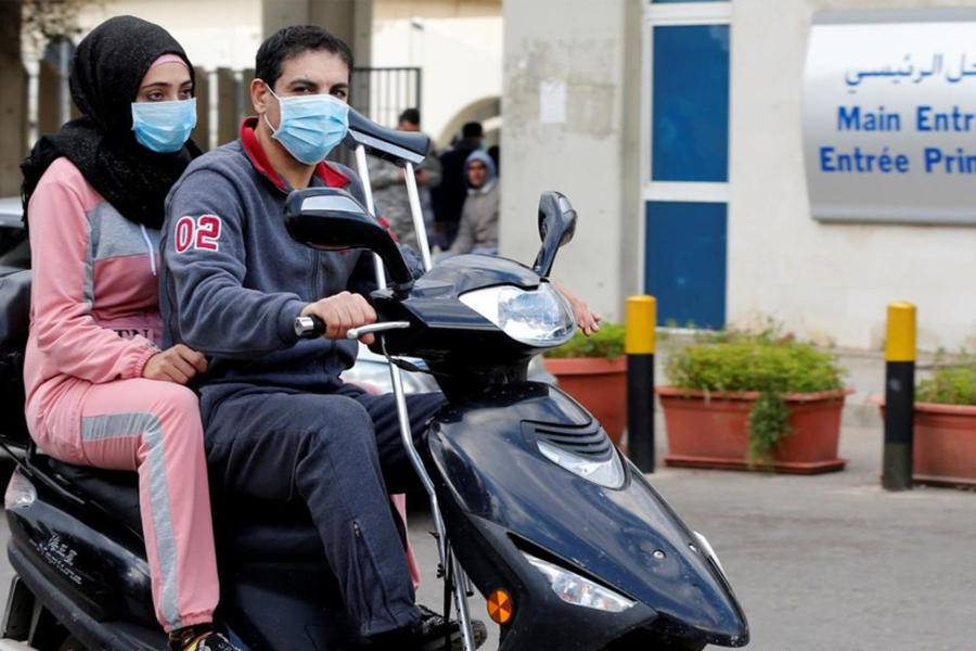 Dos personas llevan máscaras faciales frente al hospital Rafik Hariri, donde se encuentra en cuarentena el primer caso de coronavirus del Líbano, en Beirut.. FOTO: REUTERS