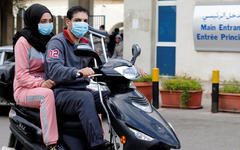 Dos personas llevan máscaras faciales frente al hospital Rafik Hariri, donde se encuentra en cuarentena el primer caso de coronavirus del Líbano, en Beirut.. FOTO: REUTERS