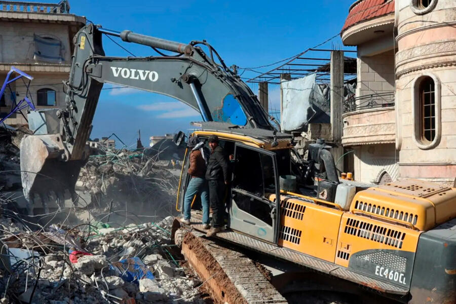 Rescatistas sirios usan una excavadora para moverse entre los escombros de un edificio derrumbado, el 7 de febrero de 2023, en la ciudad de Jindires, Alepo (Foto: Mohammed al-Rifai / AFP)