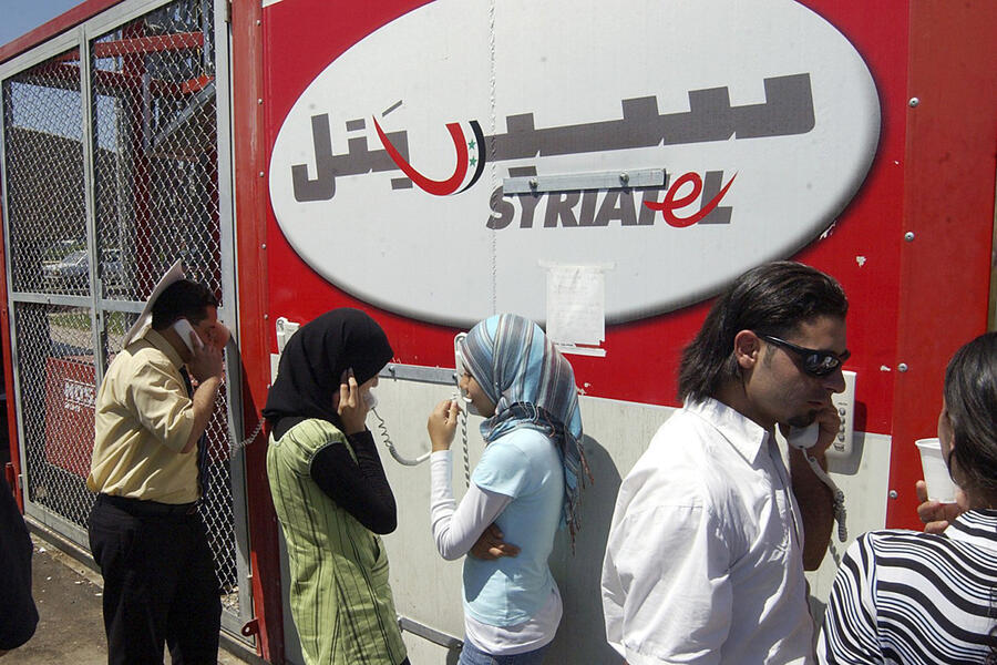 Refugiados libaneses en el cruce fronterizo sirio-libanés de Jdaidet Yabous hablan con sus familiares en el Líbano a través de teléfonos móviles proporcionados gratuitamente por la compañía de telecomunicaciones siria Syriatel, el 25 de julio de 2006 (Foto: AP)