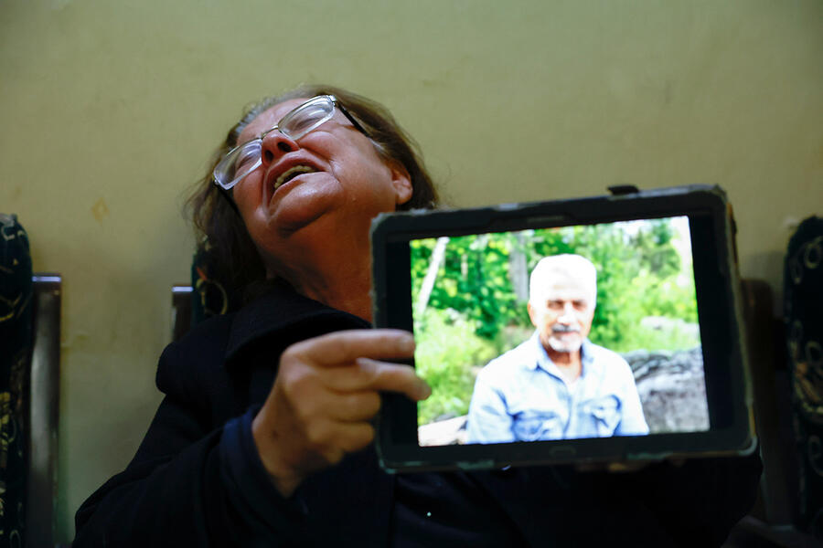 Samira Khadour muestra una foto de su esposo, quien fue asesinado junto con sus hijos adultos en Jableh. Durante tres días, permaneció con los cuerpos hasta que fue seguro enterrarlos (Foto: Reuters/Stringer)