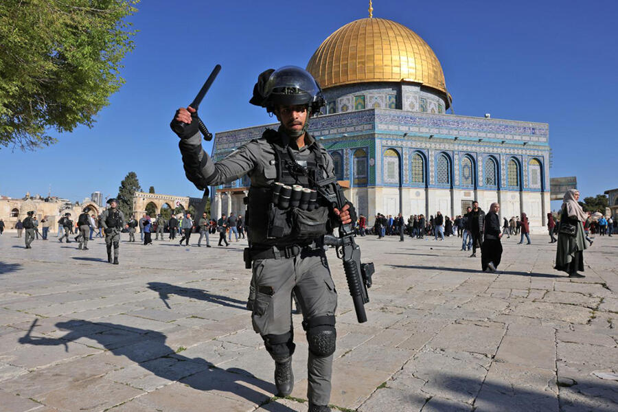 Un miembro de las fuerzas de seguridad del régimen israelí ataca a los fieles en la mezquita de la Cúpula de la Roca en el complejo de al-Aqsa de Jerusalén | Abril 15, 2022 (Foto: AFP)