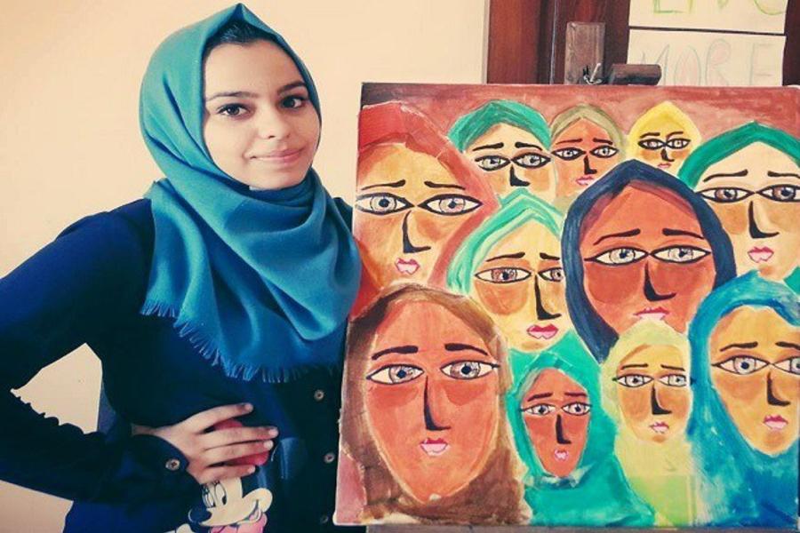 Malak Mattar junto a una de sus pinturas. 
